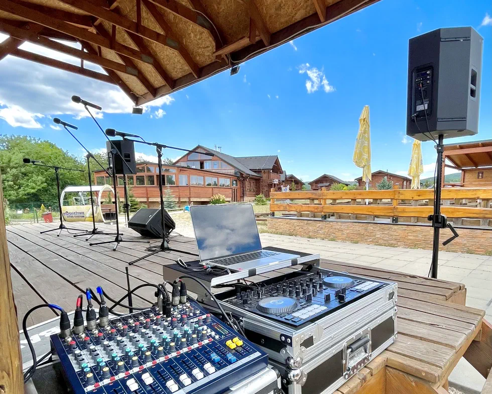 DJ konzola, mixážny pult a reproduktory pripravené na vonkajšej terase