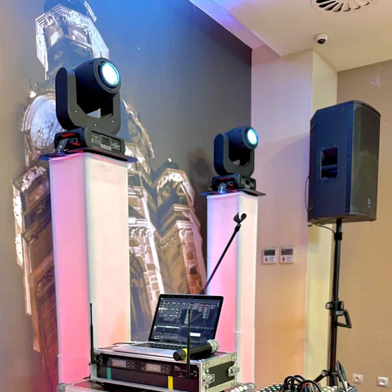 DJ pult s pohyblivými svetelnými hlavicami na stojanoch a reproduktorom